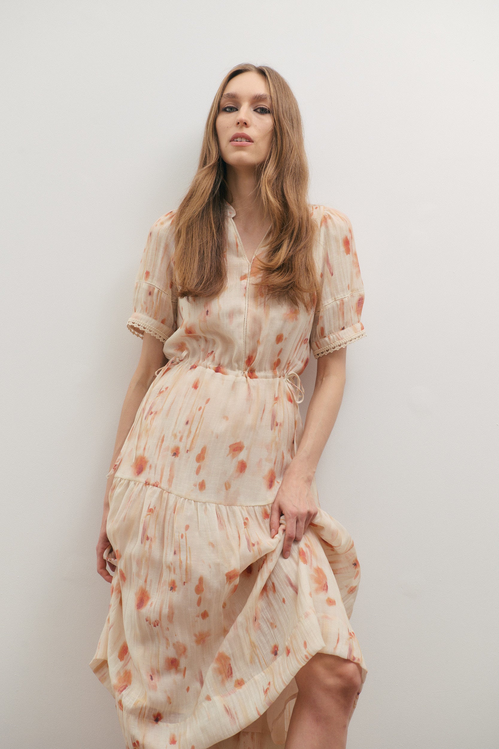 Woman wearing a floral dress against a plain background