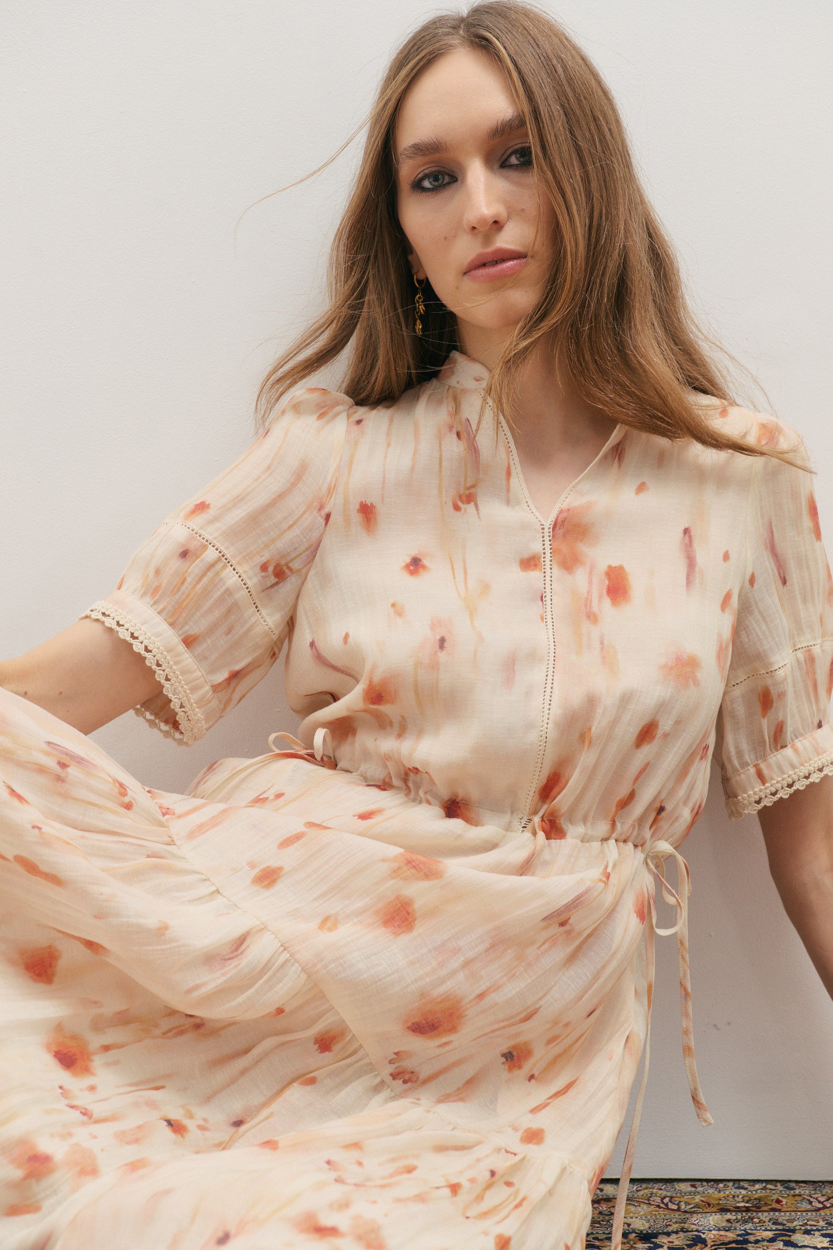 Woman wearing a floral dress against a plain background