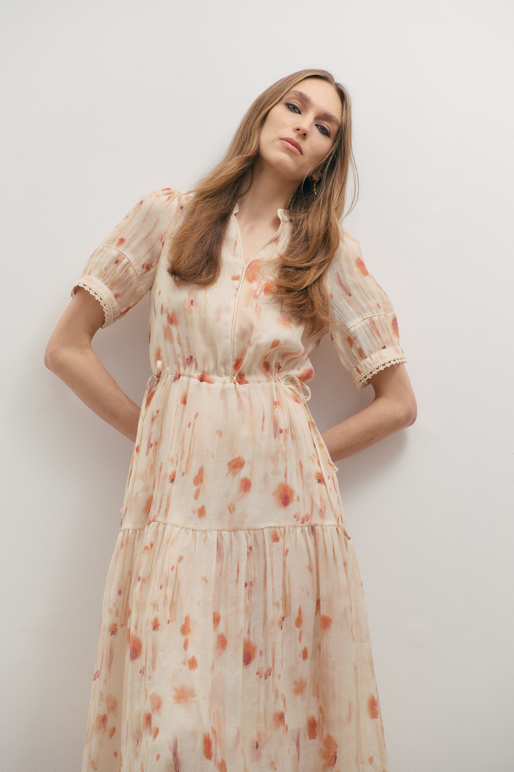 Woman wearing a floral dress against a plain background