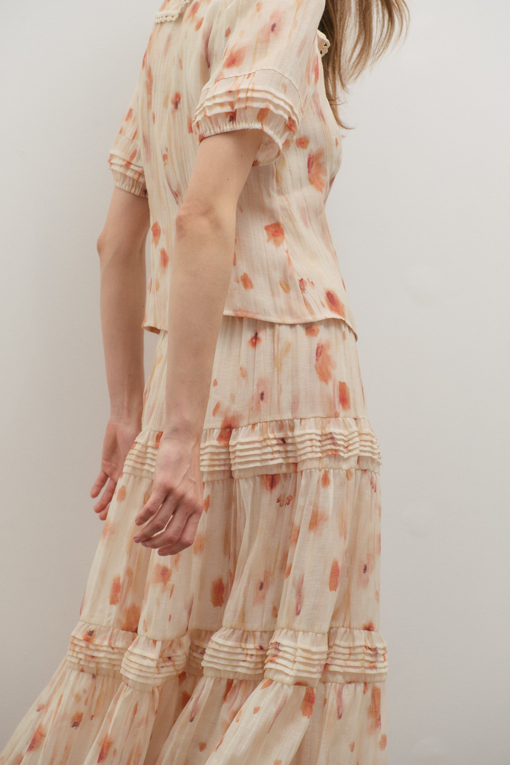 Woman wearing a floral Maevarii outfit with a plain background