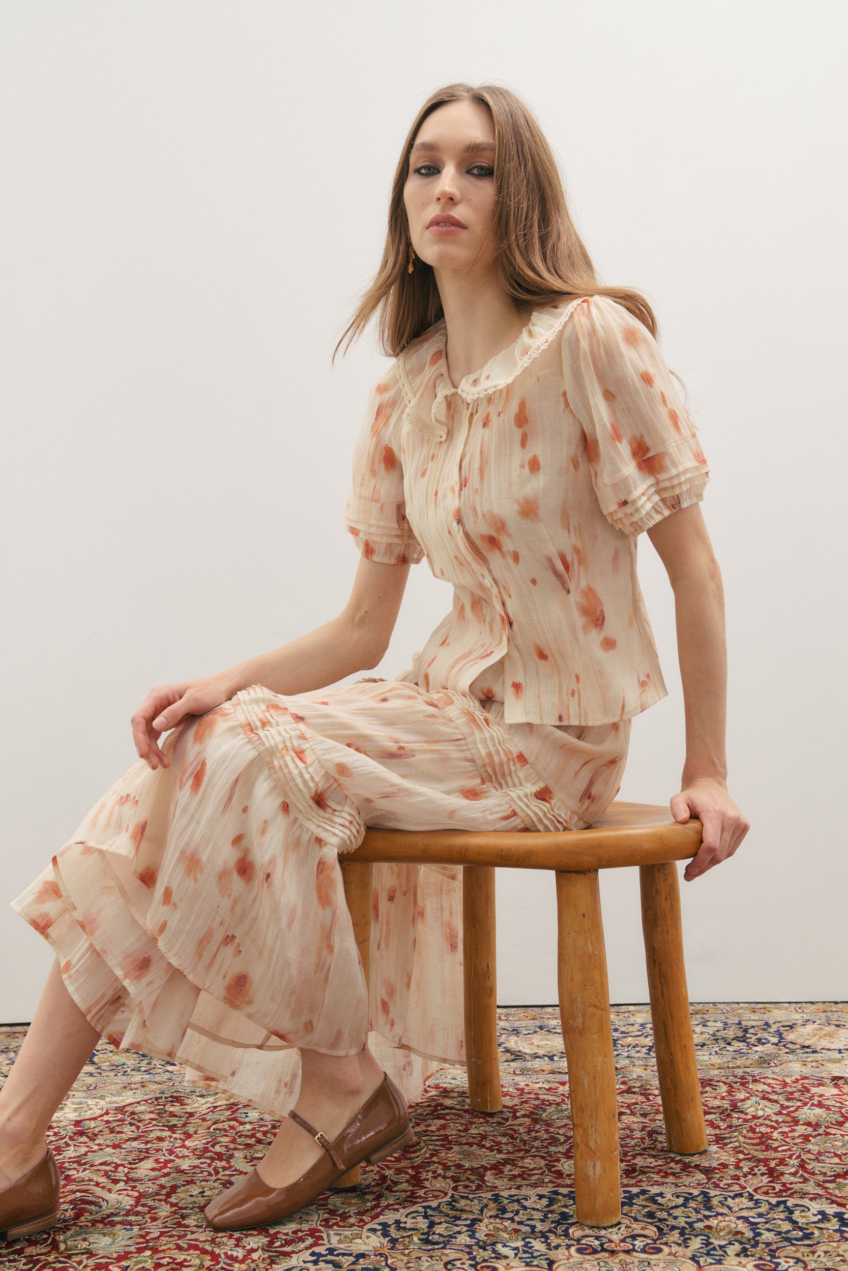woman sitting on a chair wearing a beautiful and romantic outfit by Australian fashion brand Maevarii from the Fall 2026 collection