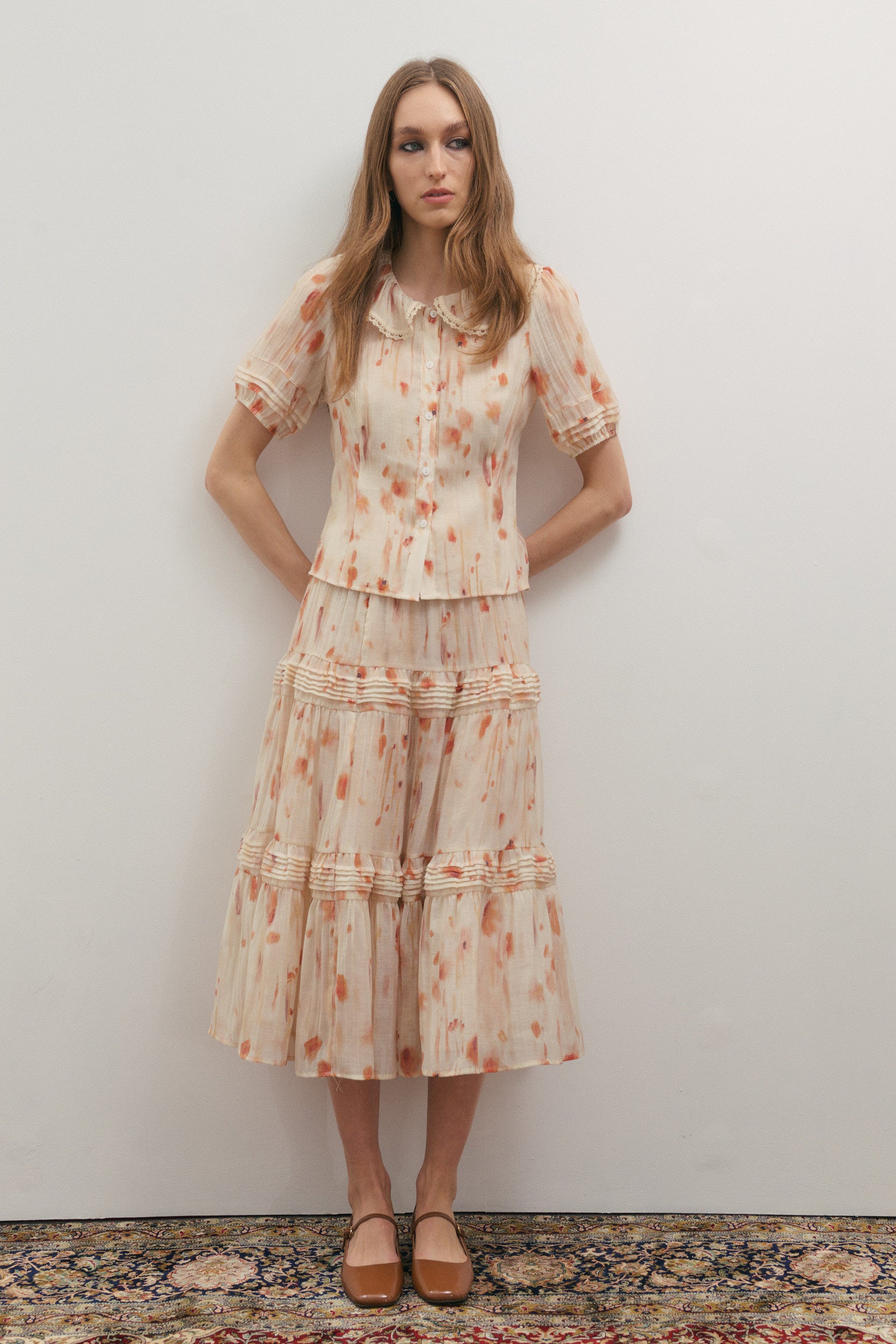 woman wearing a pleated midi skirt and matching short sleeve shirt