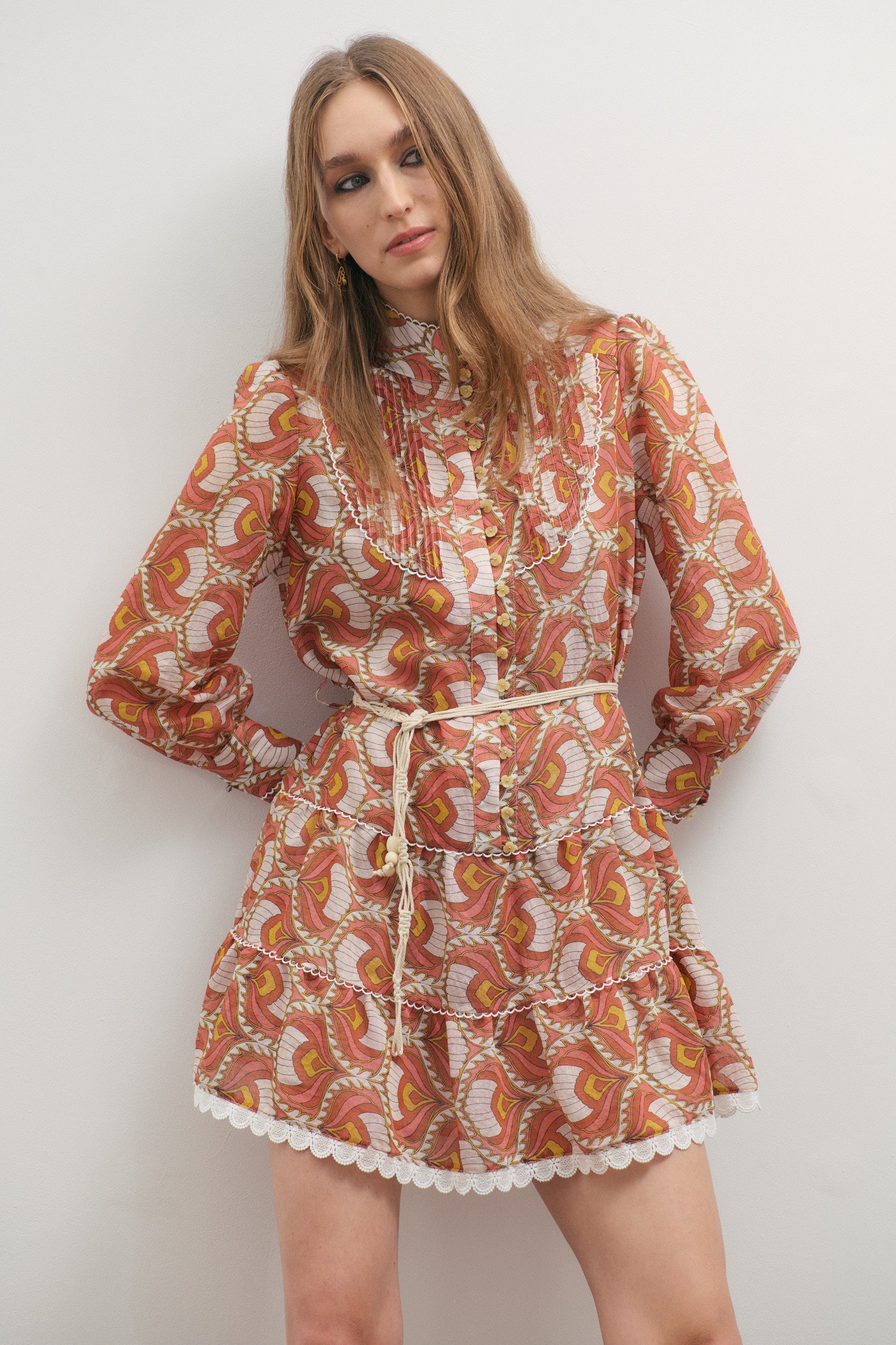Woman wearing a patterned dress against a plain background