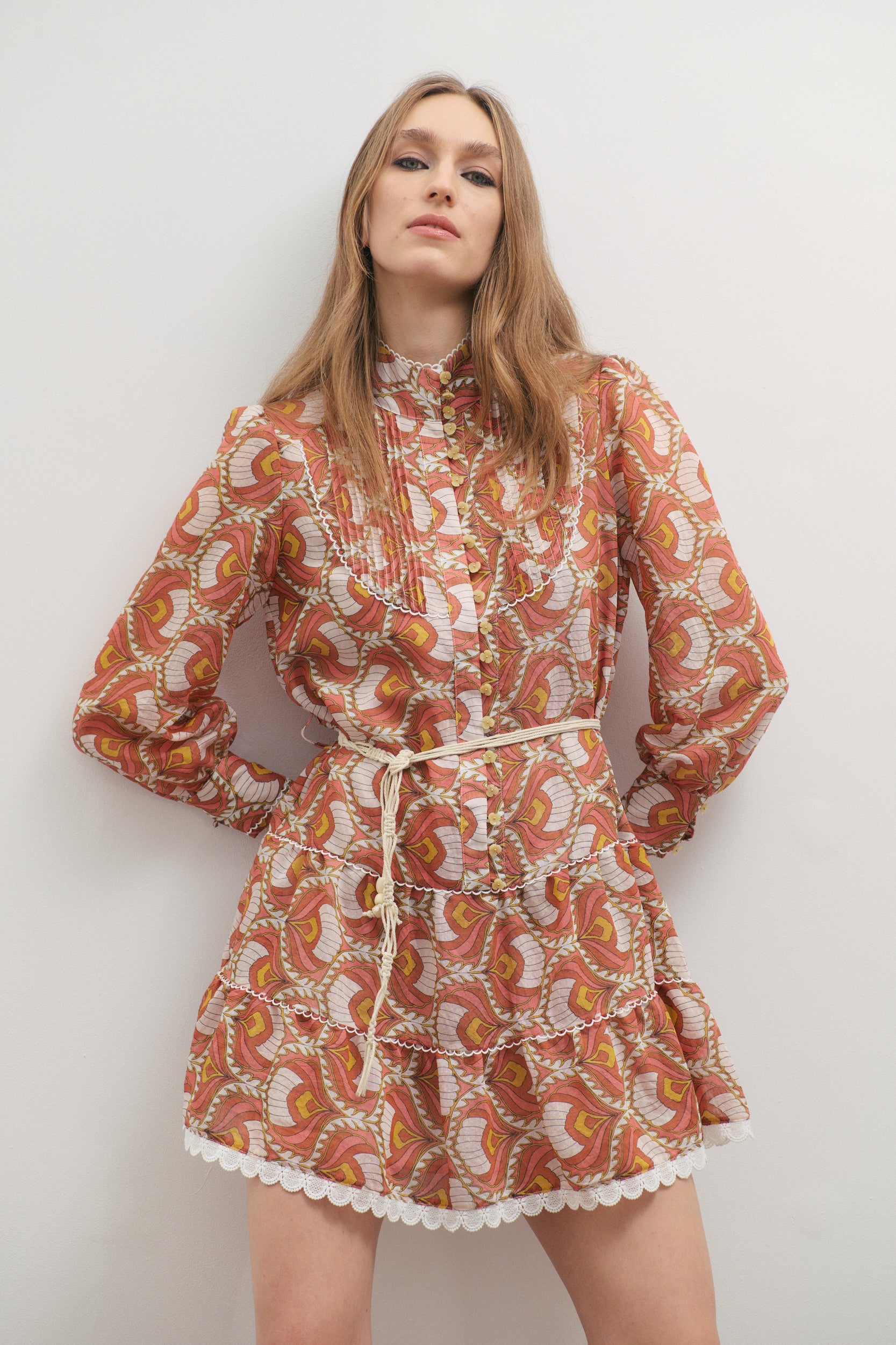 Woman wearing a patterned dress against a plain background