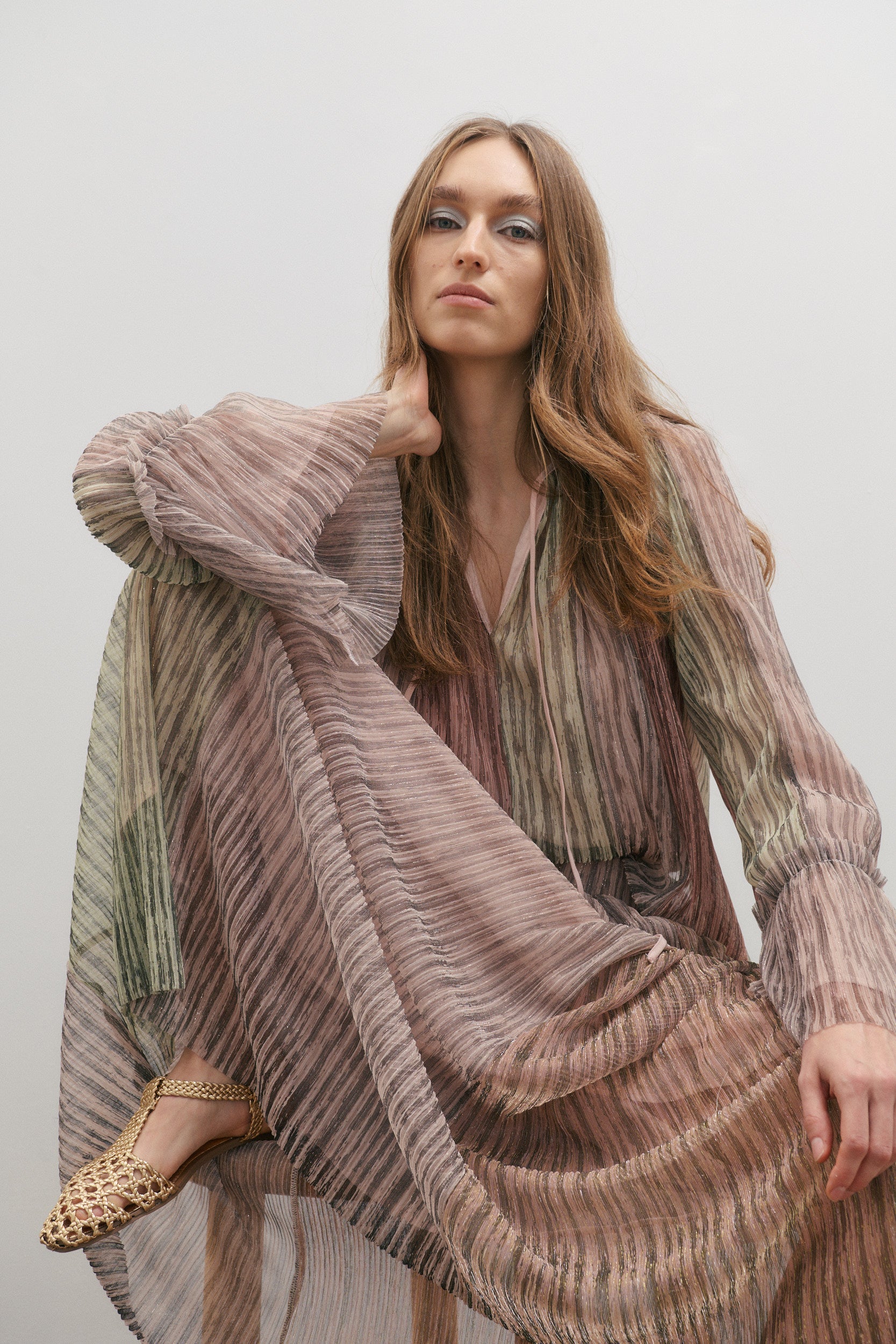 Woman wearing a long, flowing outfit by Maevarii with a neutral background