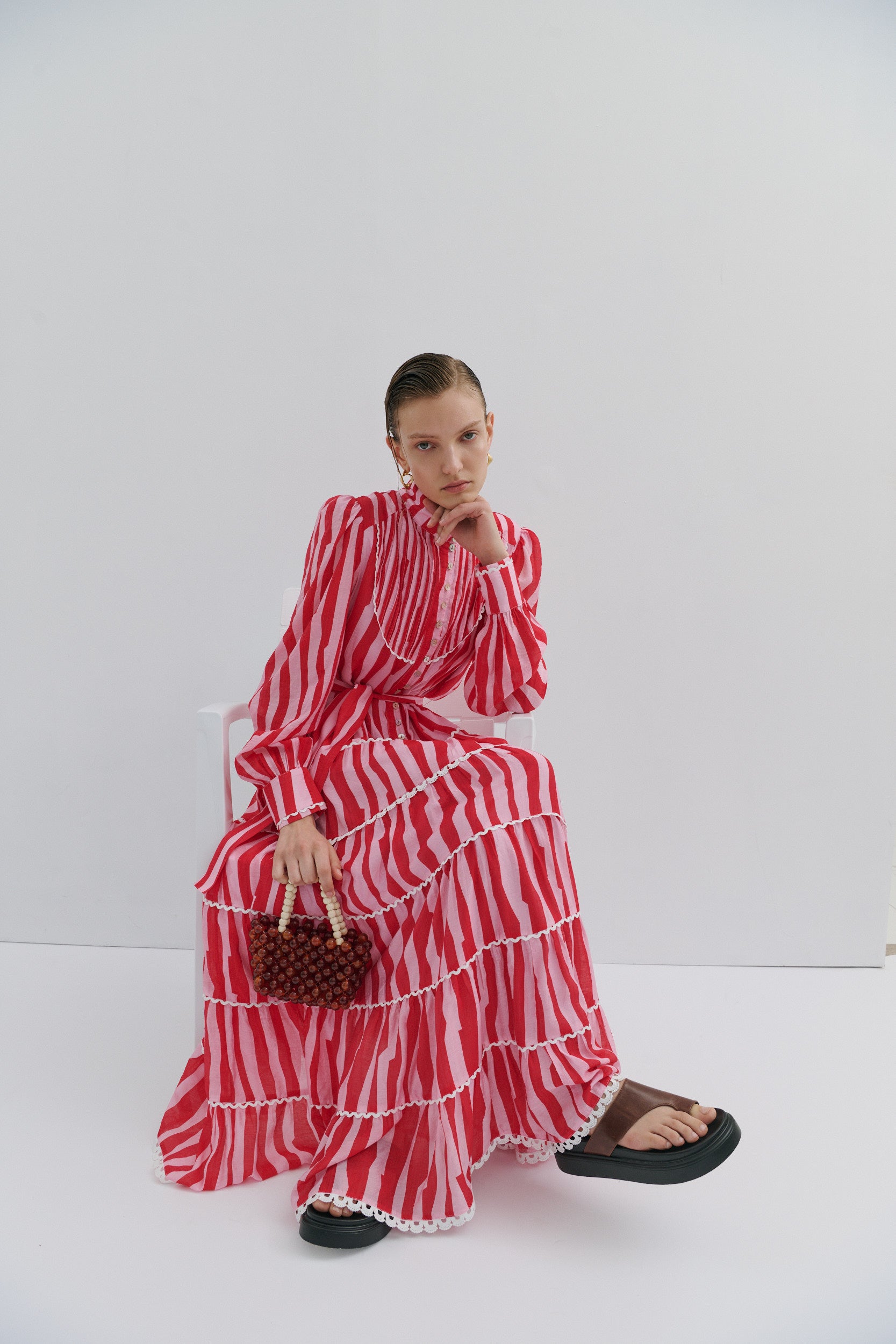Woman wearing a red and white striped dress against a white background