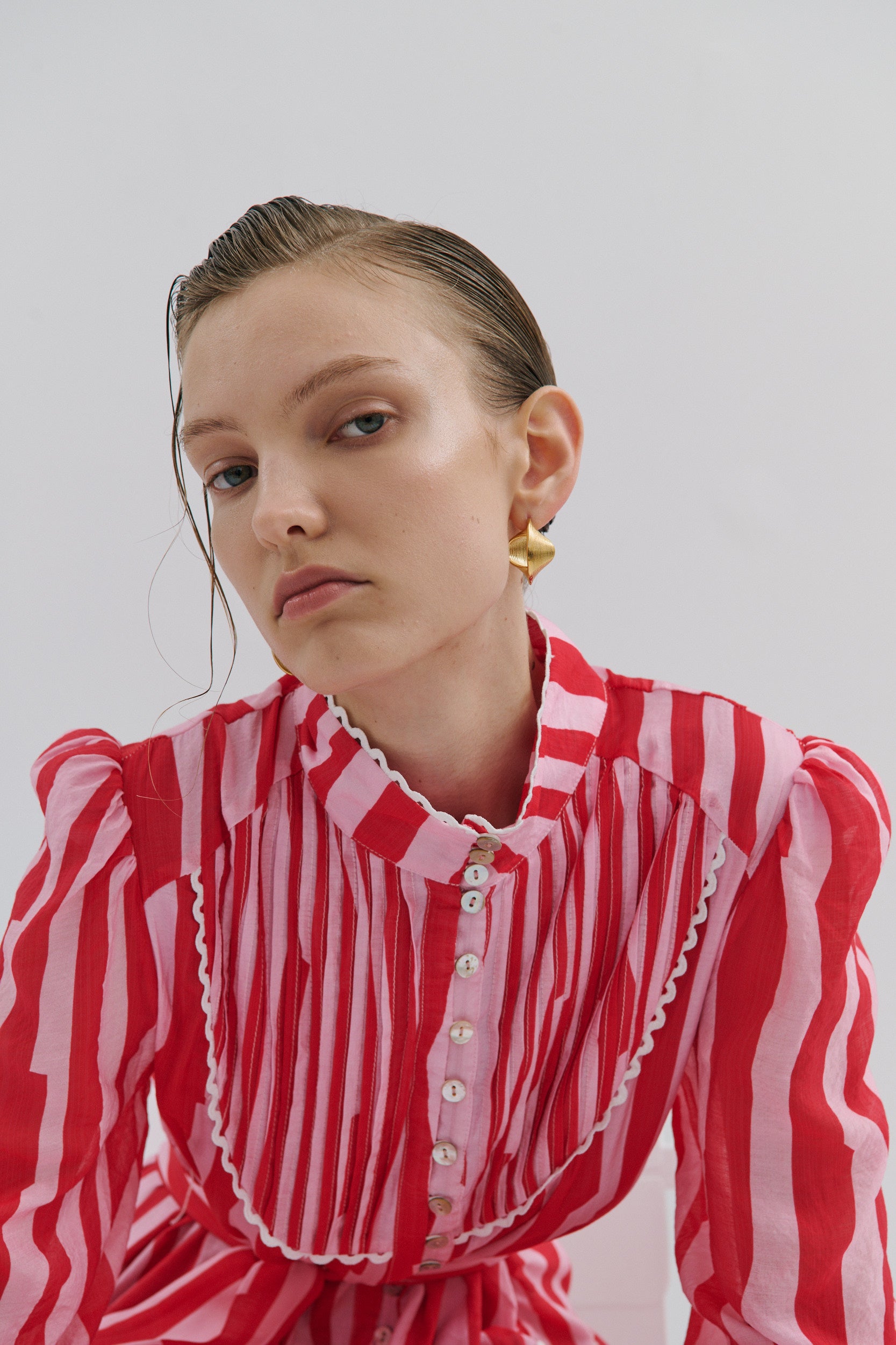 Woman wearing a red and white striped dress with a plain background