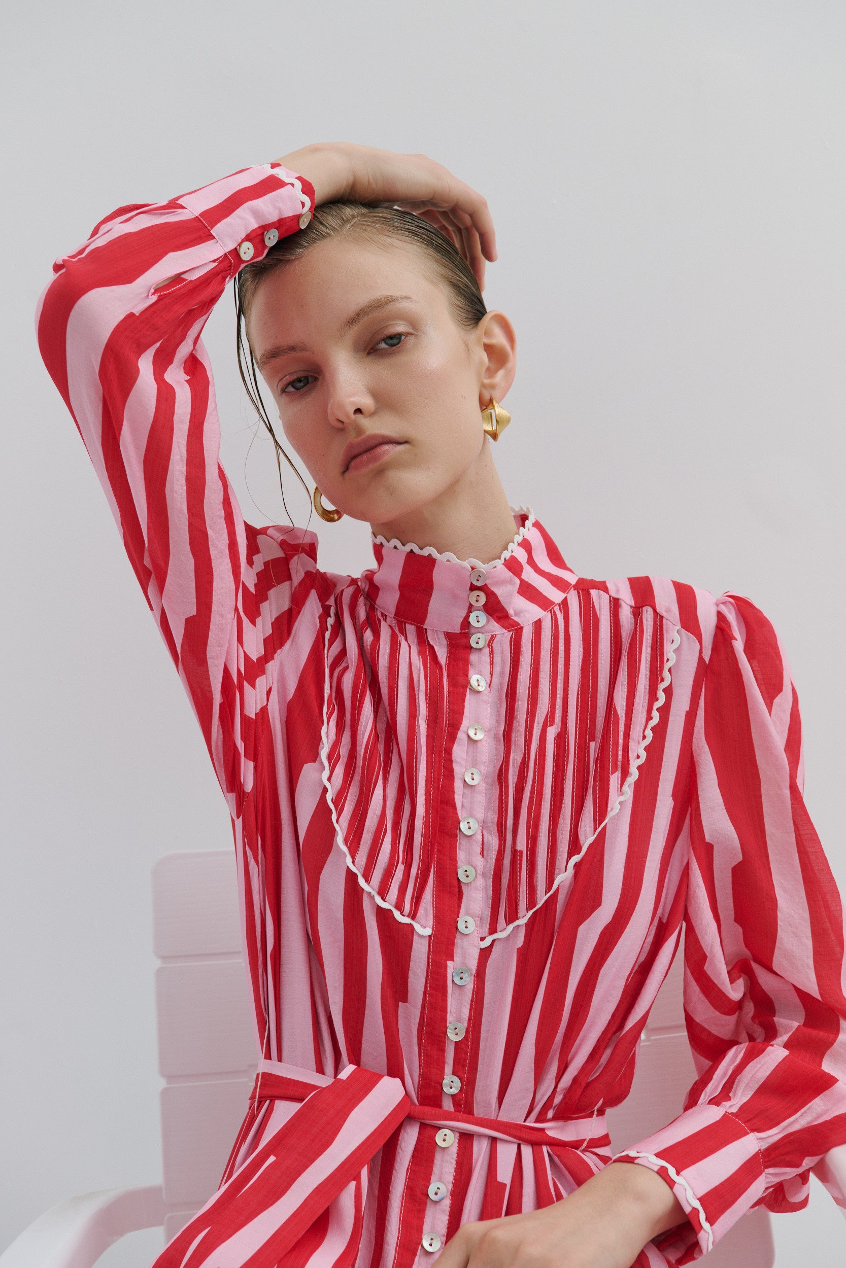 Woman wearing a red and white striped dress against a plain background