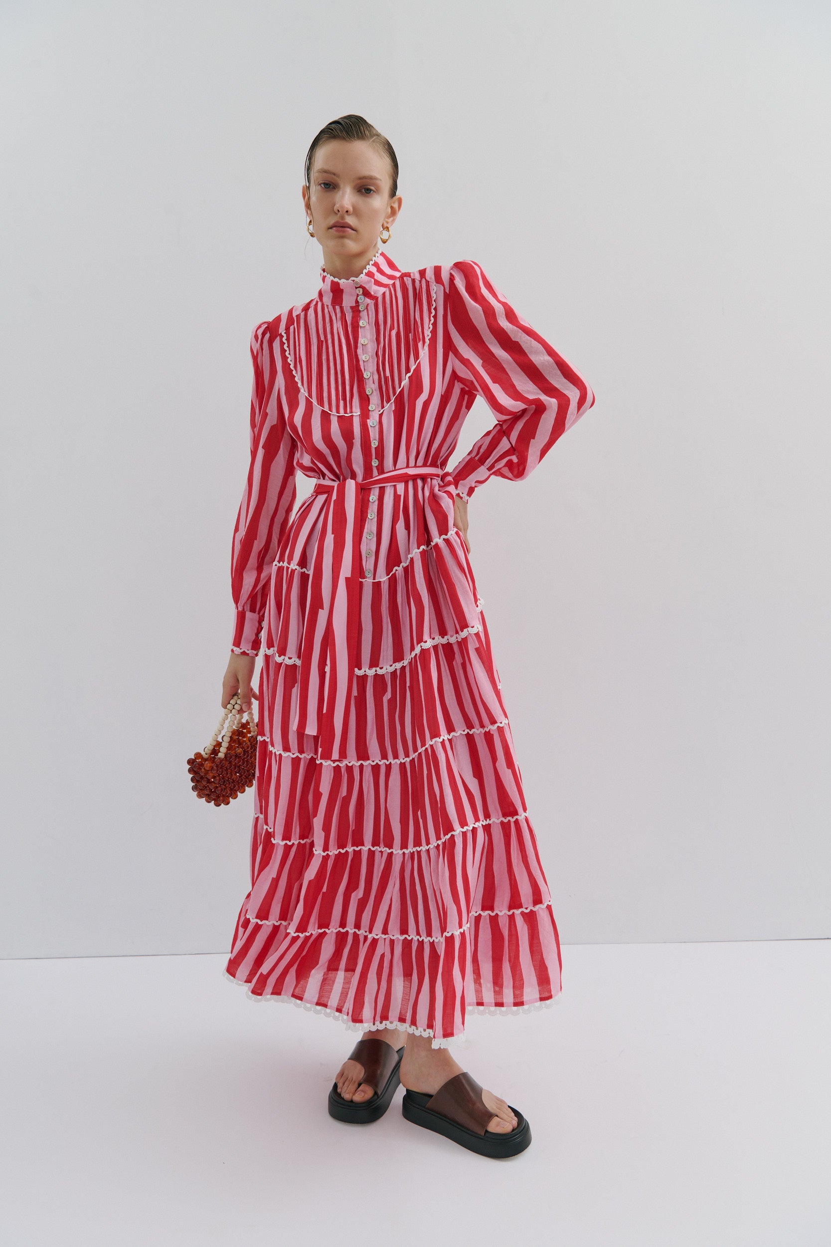 Woman wearing a red and white striped dress against a white background