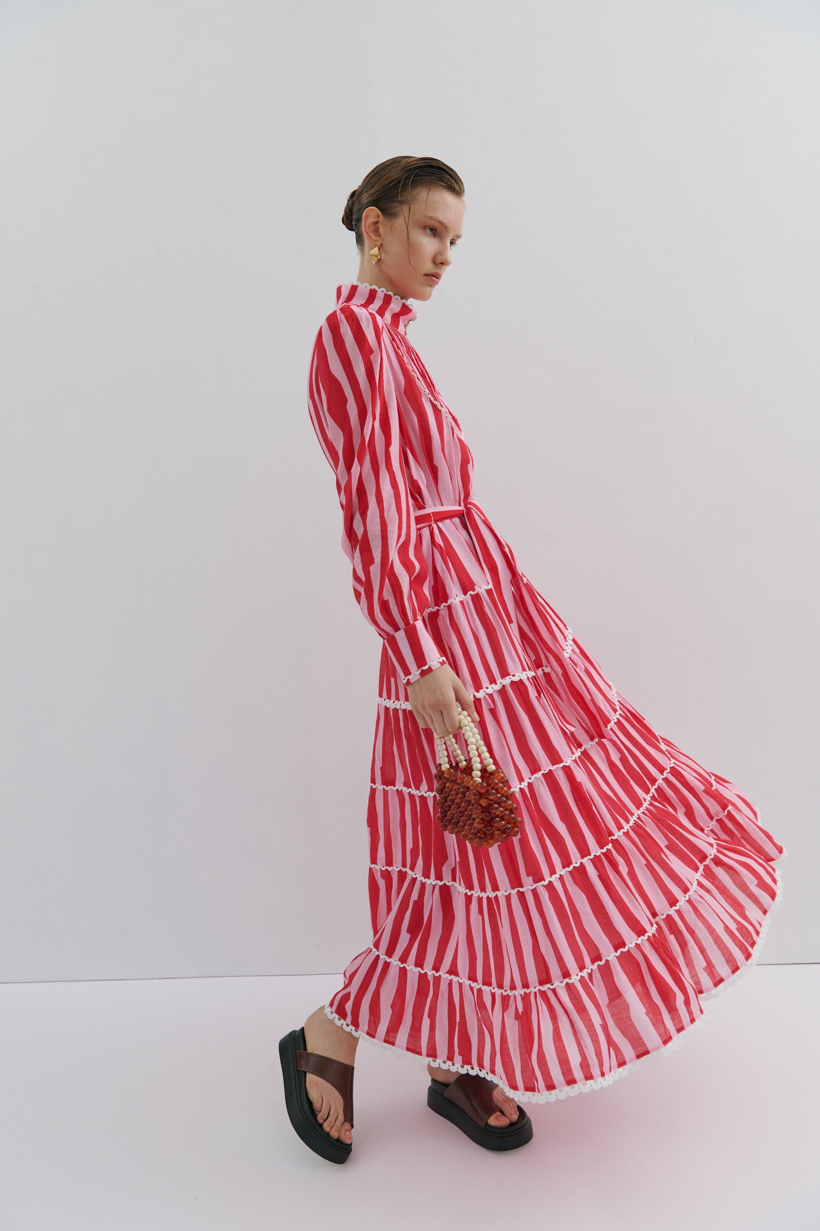 Woman wearing a red and white striped dress on a white background