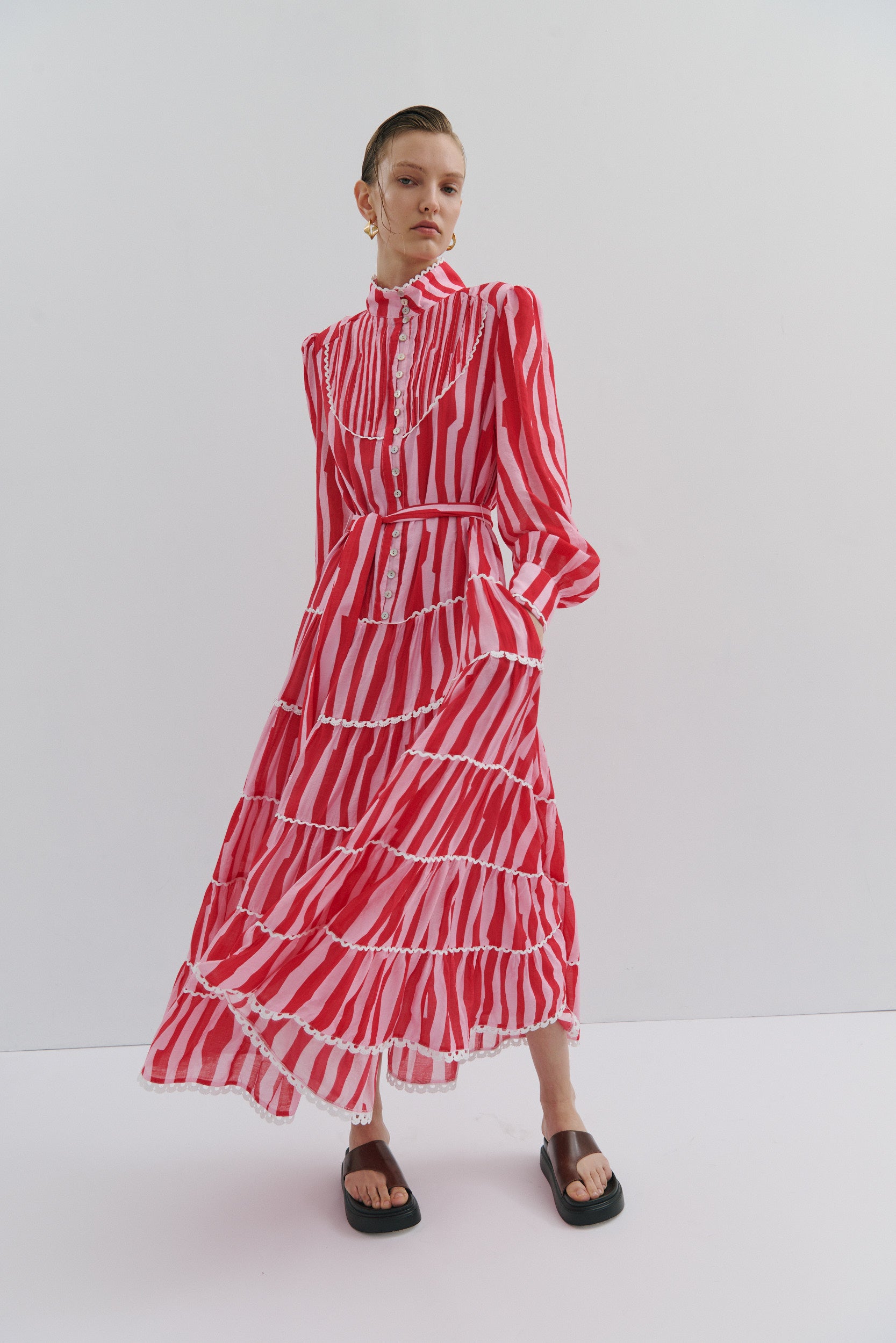 Woman wearing a red and white striped dress on a white background