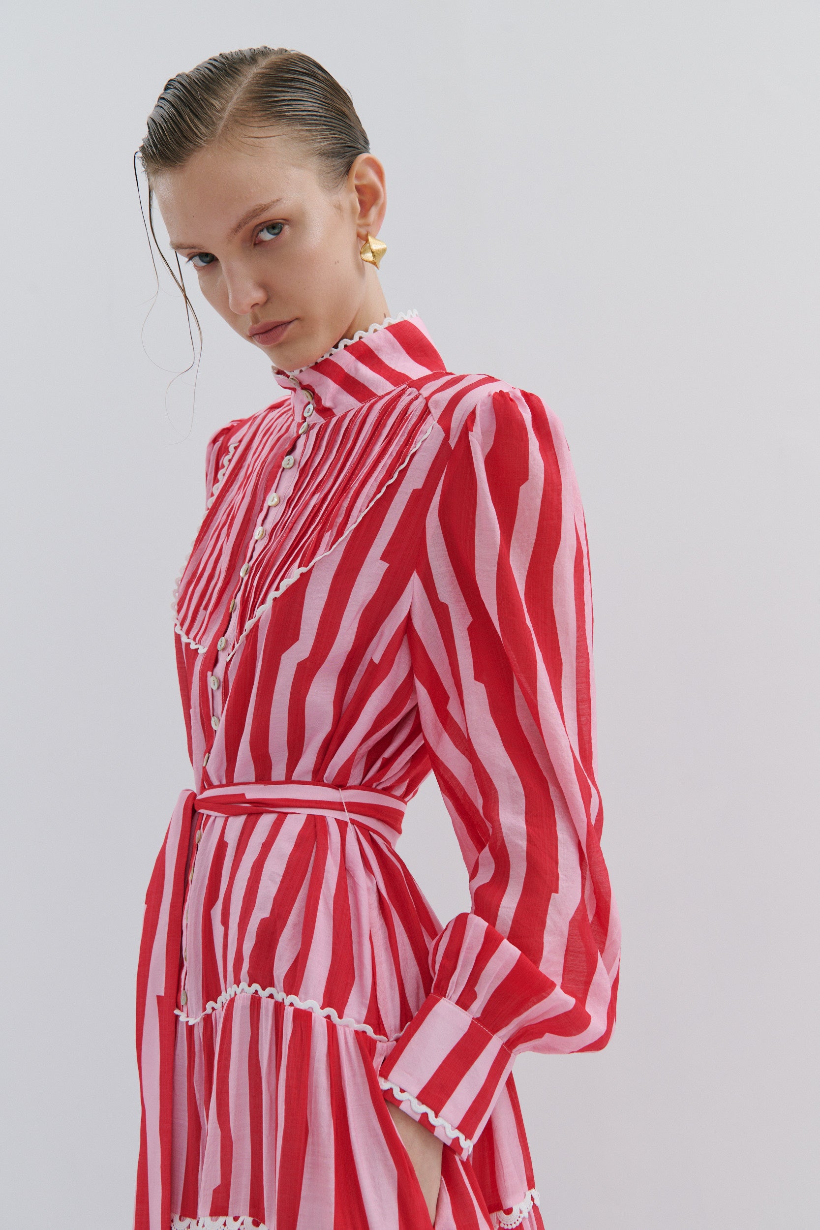 Woman wearing a red and white striped dress against a plain background