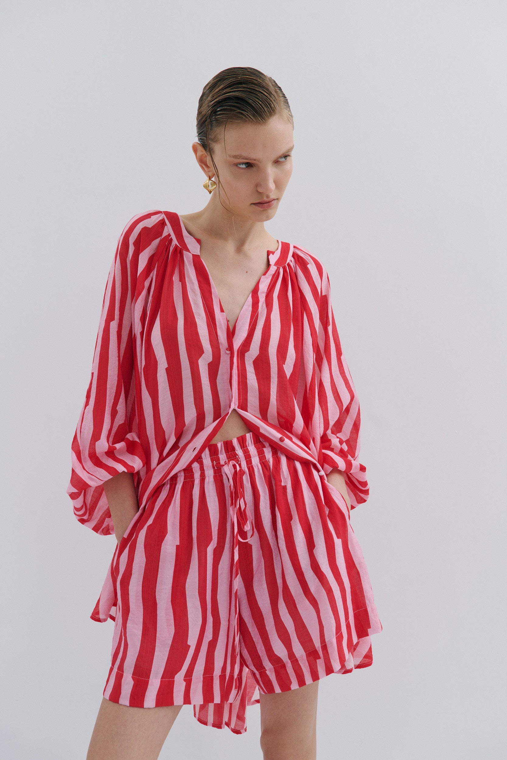 Woman wearing a red and white striped outfit on a plain background