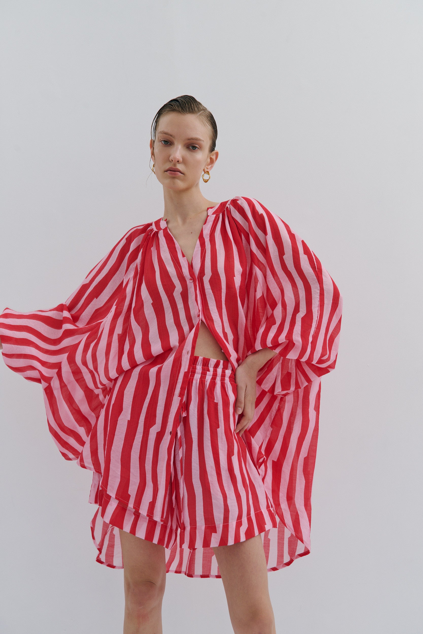 Person wearing a red and white striped outfit on a plain background