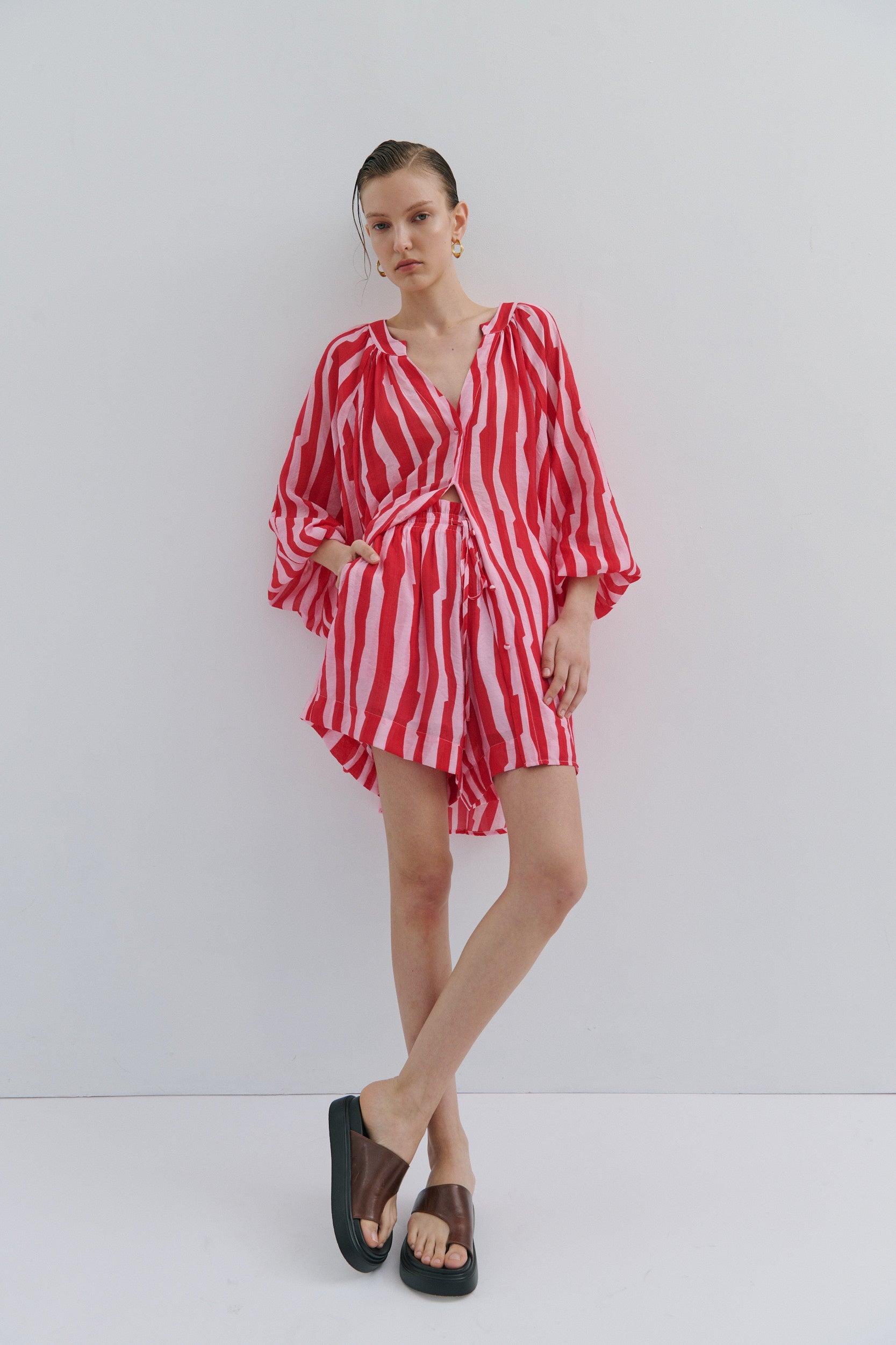 Woman wearing a red striped outfit on a white background