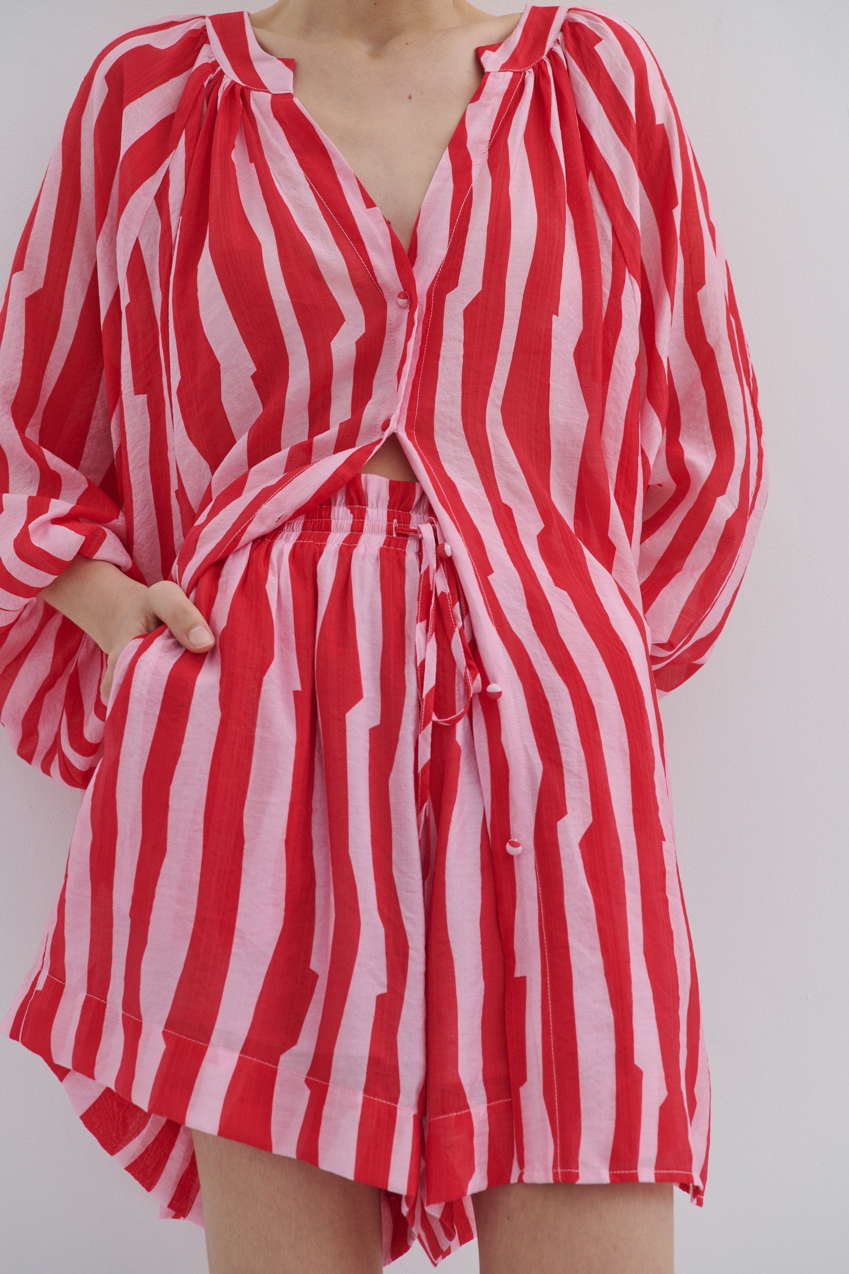 Red and white striped shirt with long sleeves on a plain background