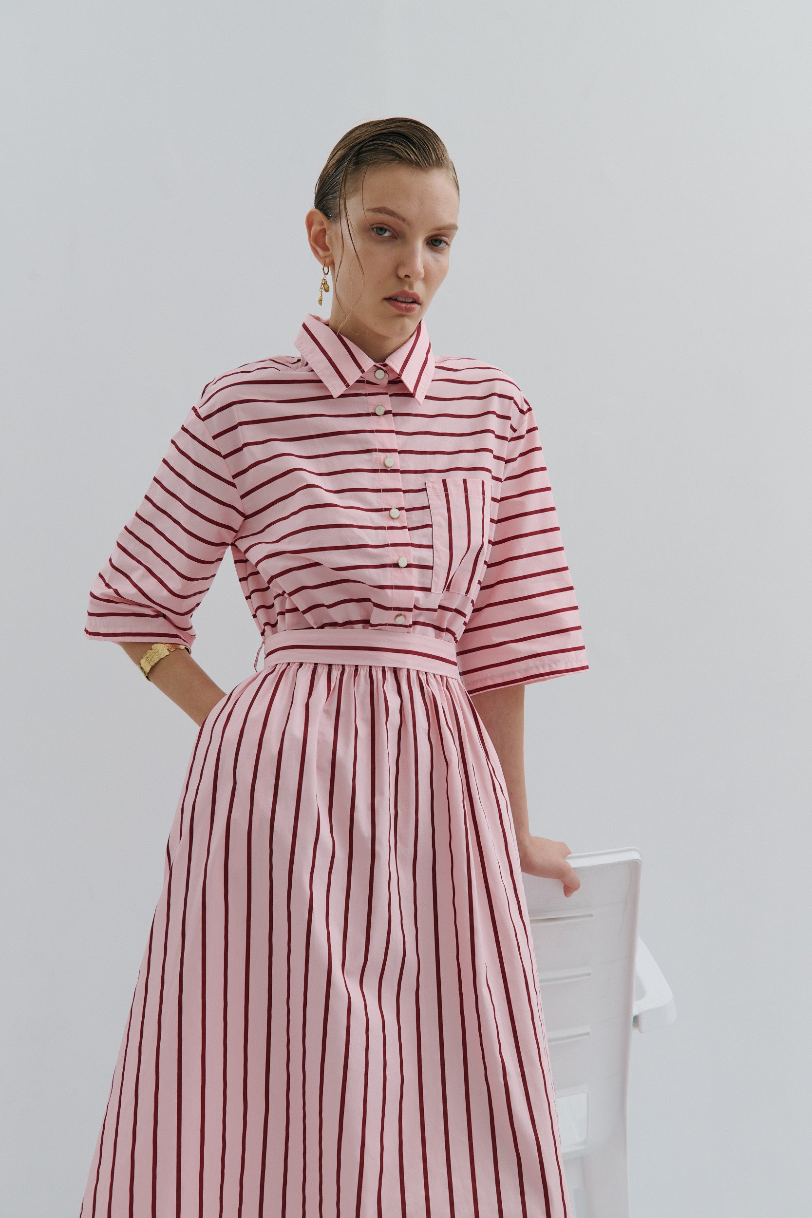 Woman wearing Maevarii Mad Hatters Midi Dress in a pink and red stripe cotton poplin fabric