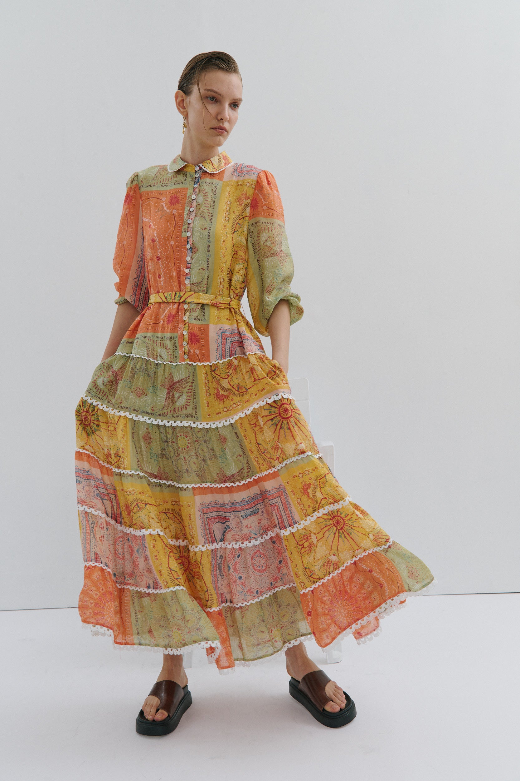 Model wearing a colorful patchwork dress on a white background