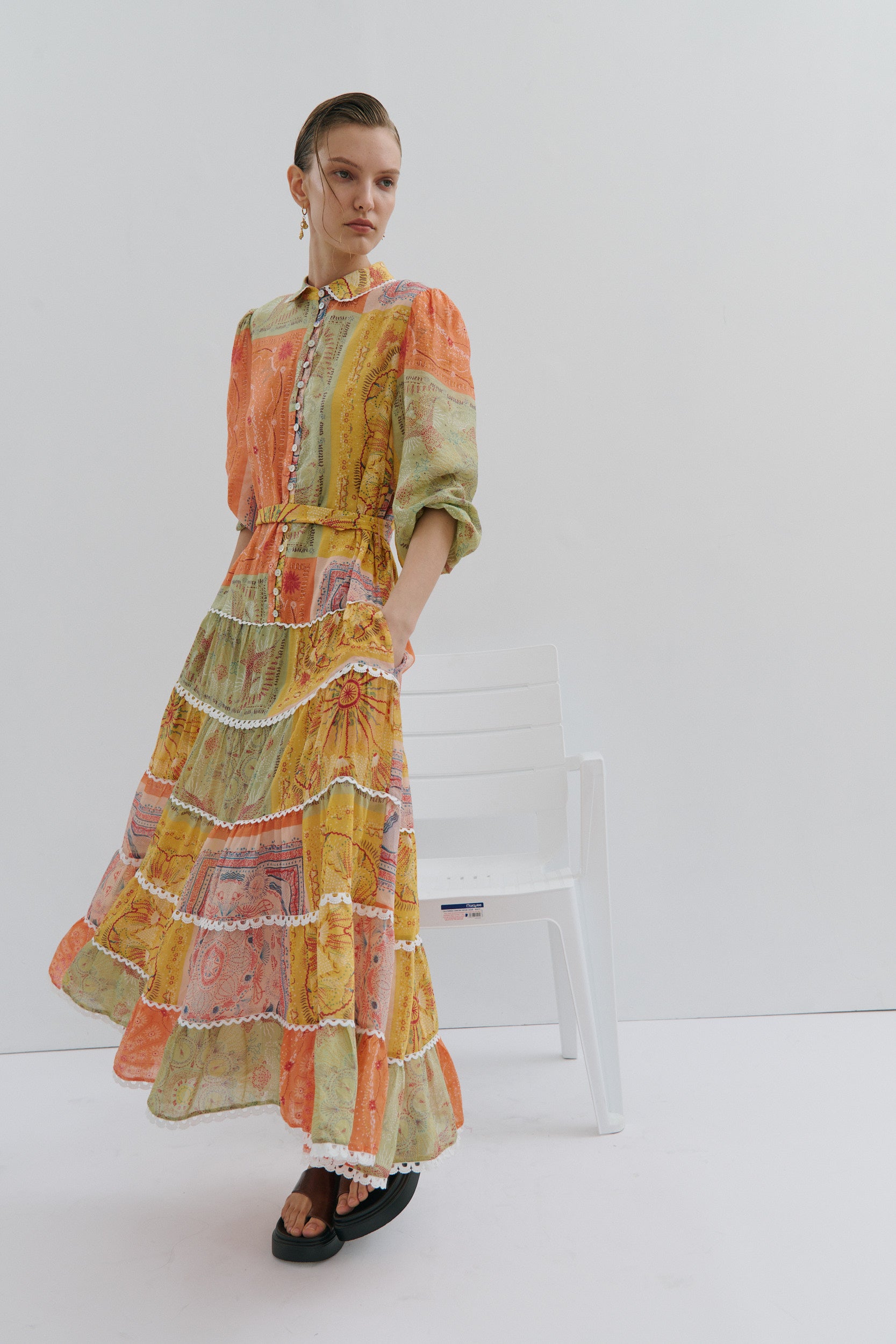 Woman wearing a colorful patchwork dress on a white background