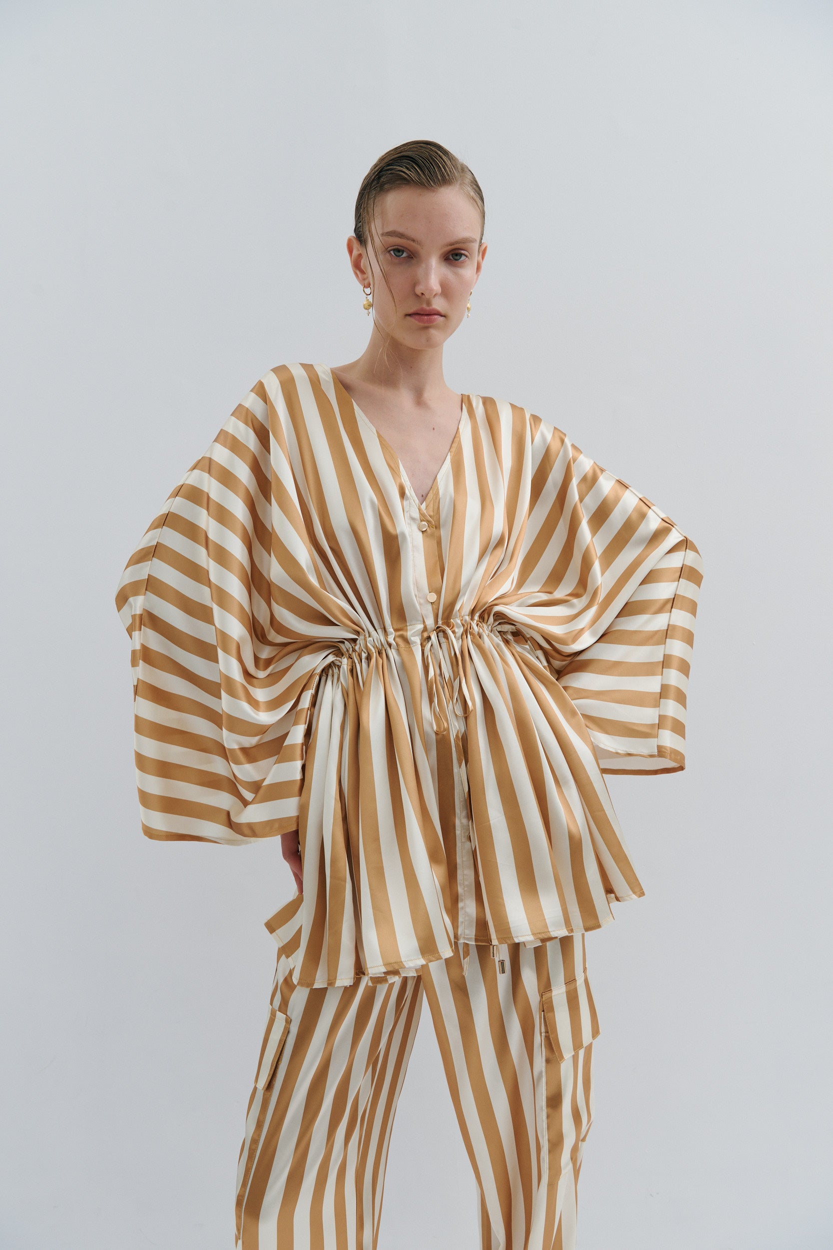 Woman wearing a striped outfit on a plain background