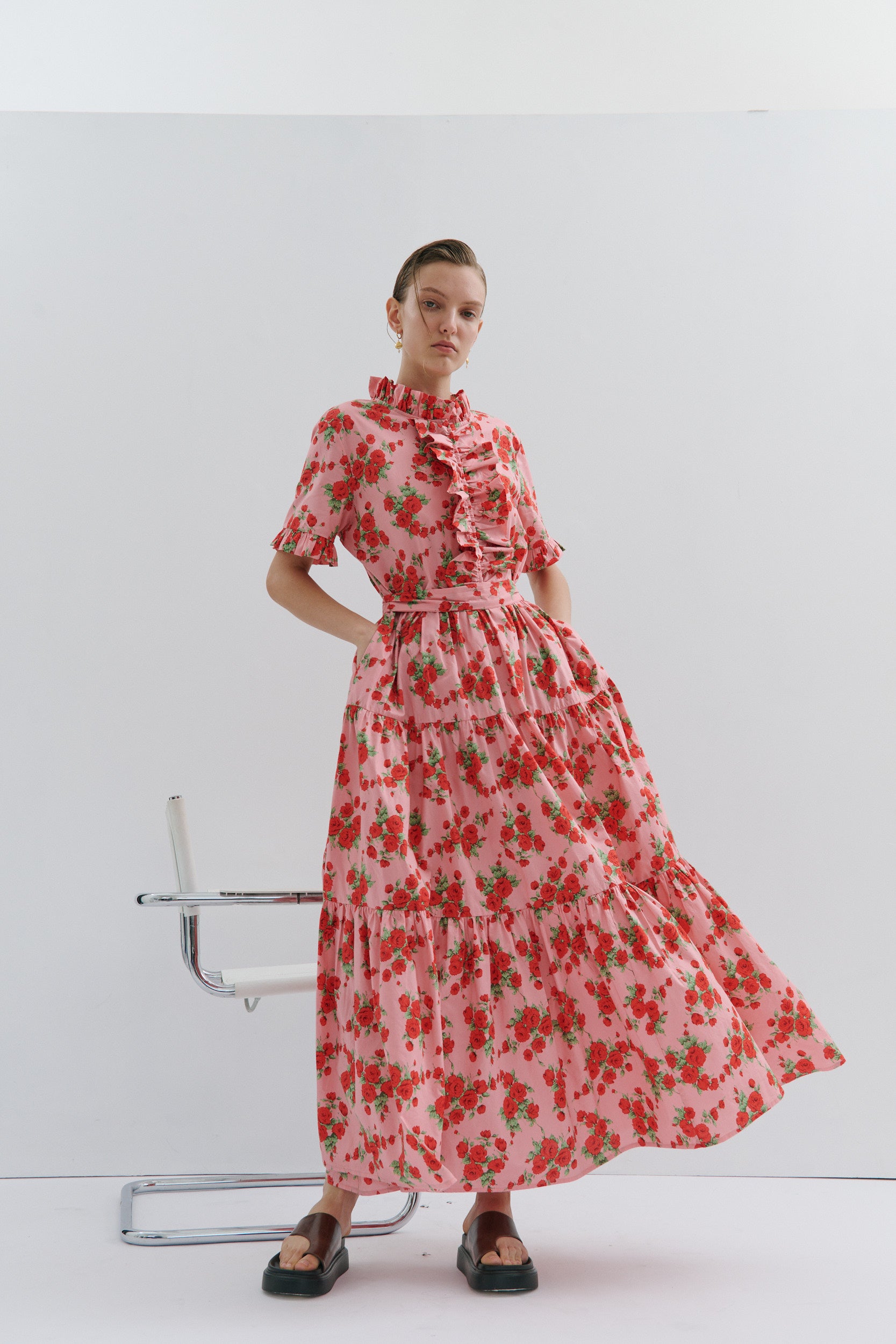 Woman wearing a red floral dress on a white background