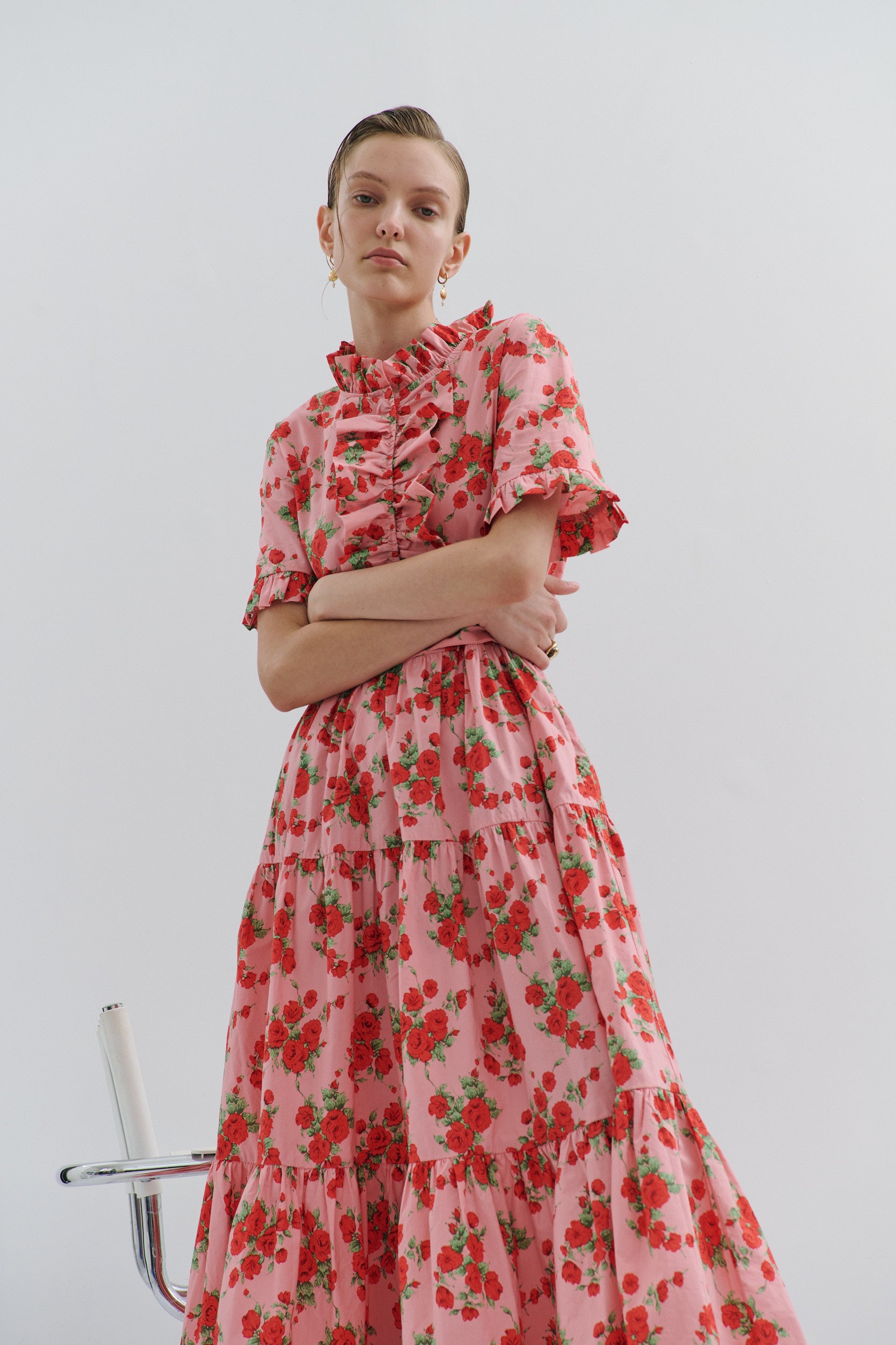 Woman wearing a pink floral dress against a plain background