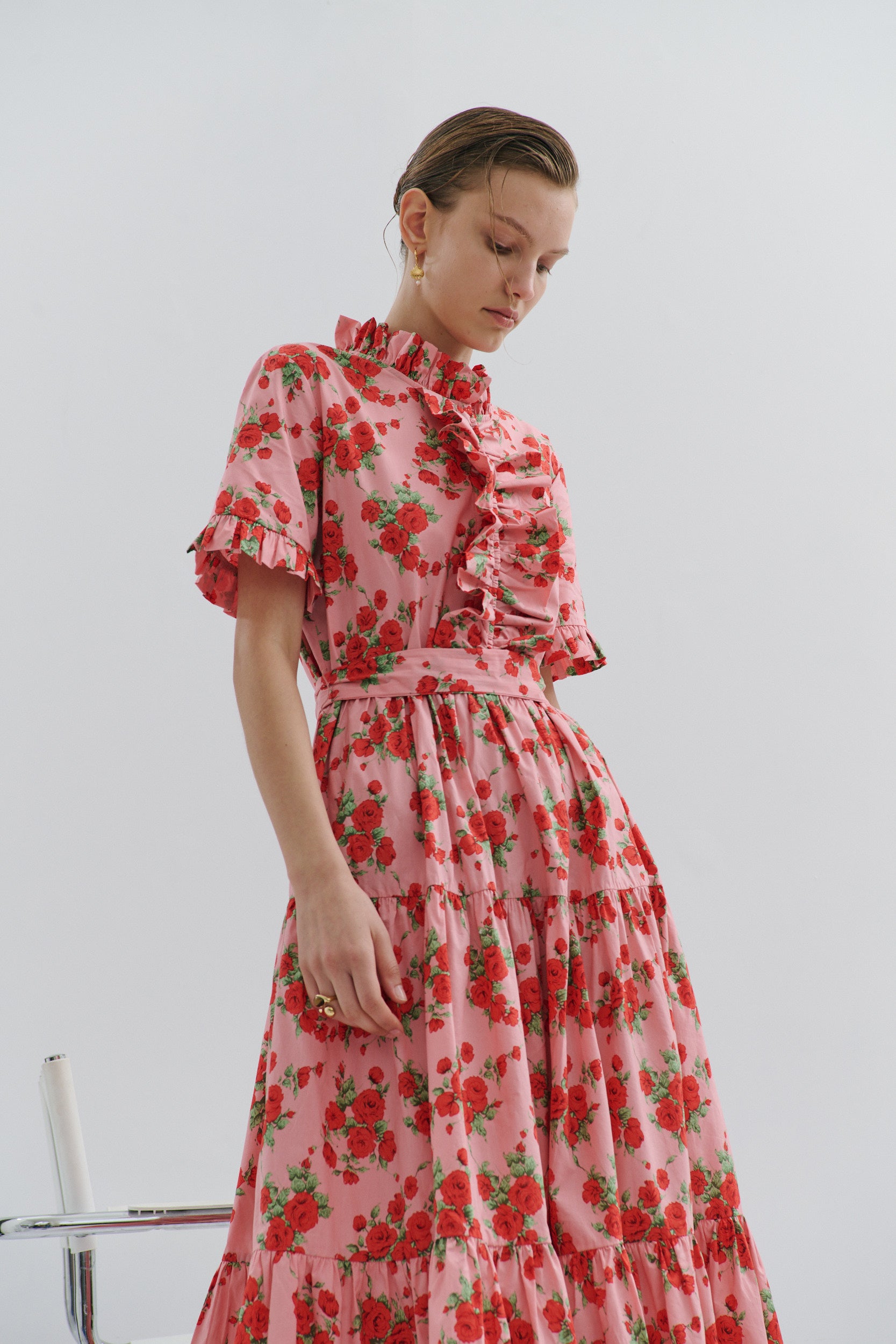 Woman wearing a pink floral dress against a white background