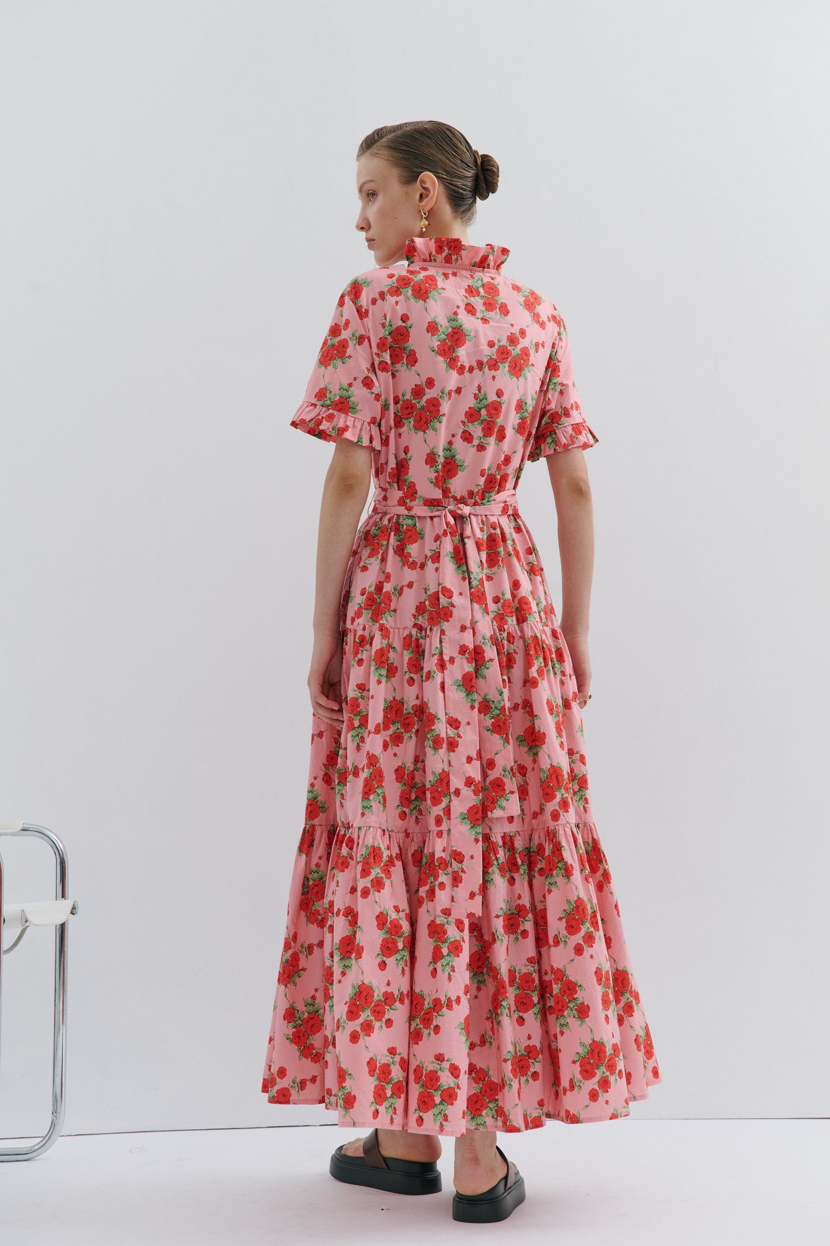 Woman wearing a pink floral dress on a white background