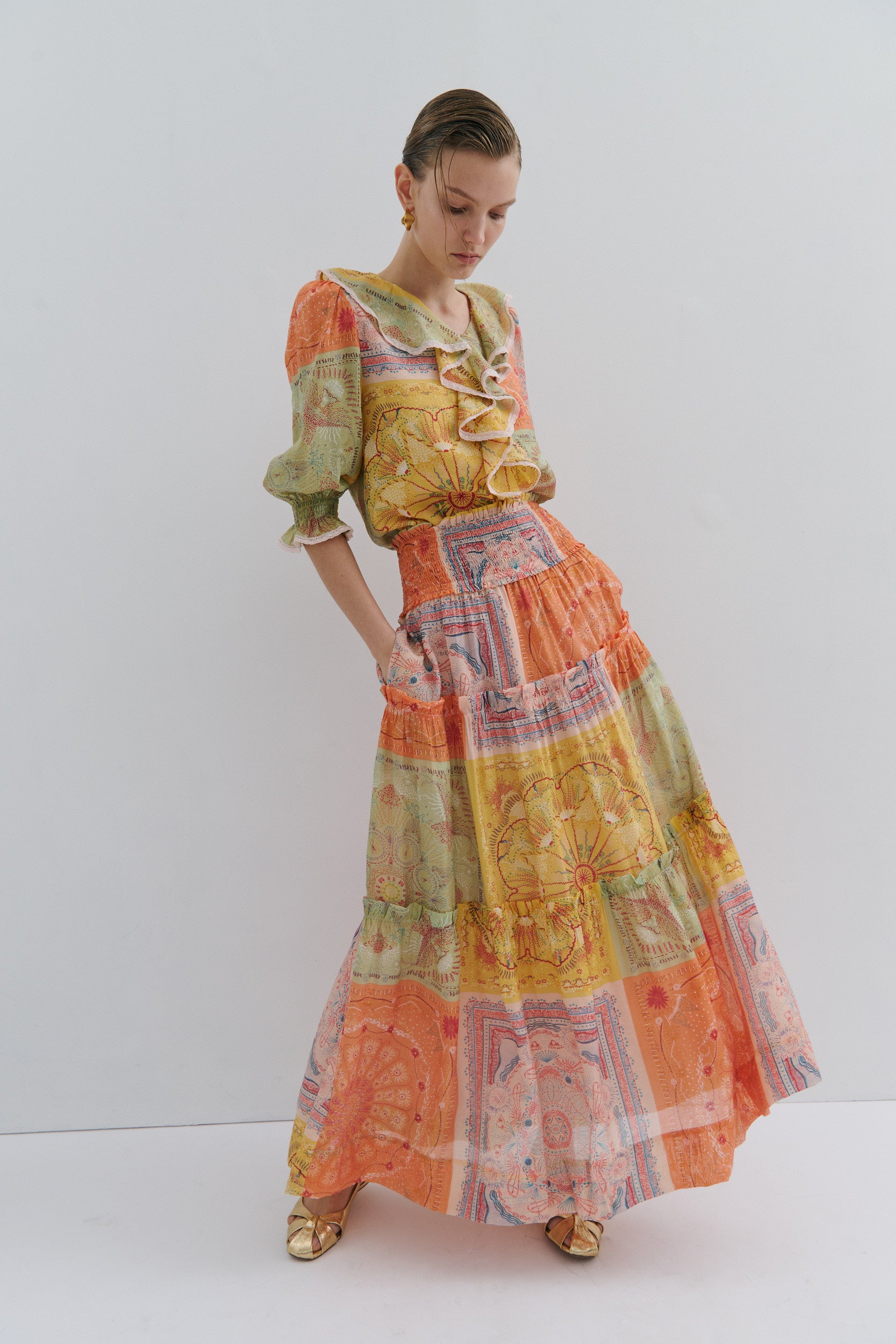 Woman wearing a colorful patterned outfit on a white background