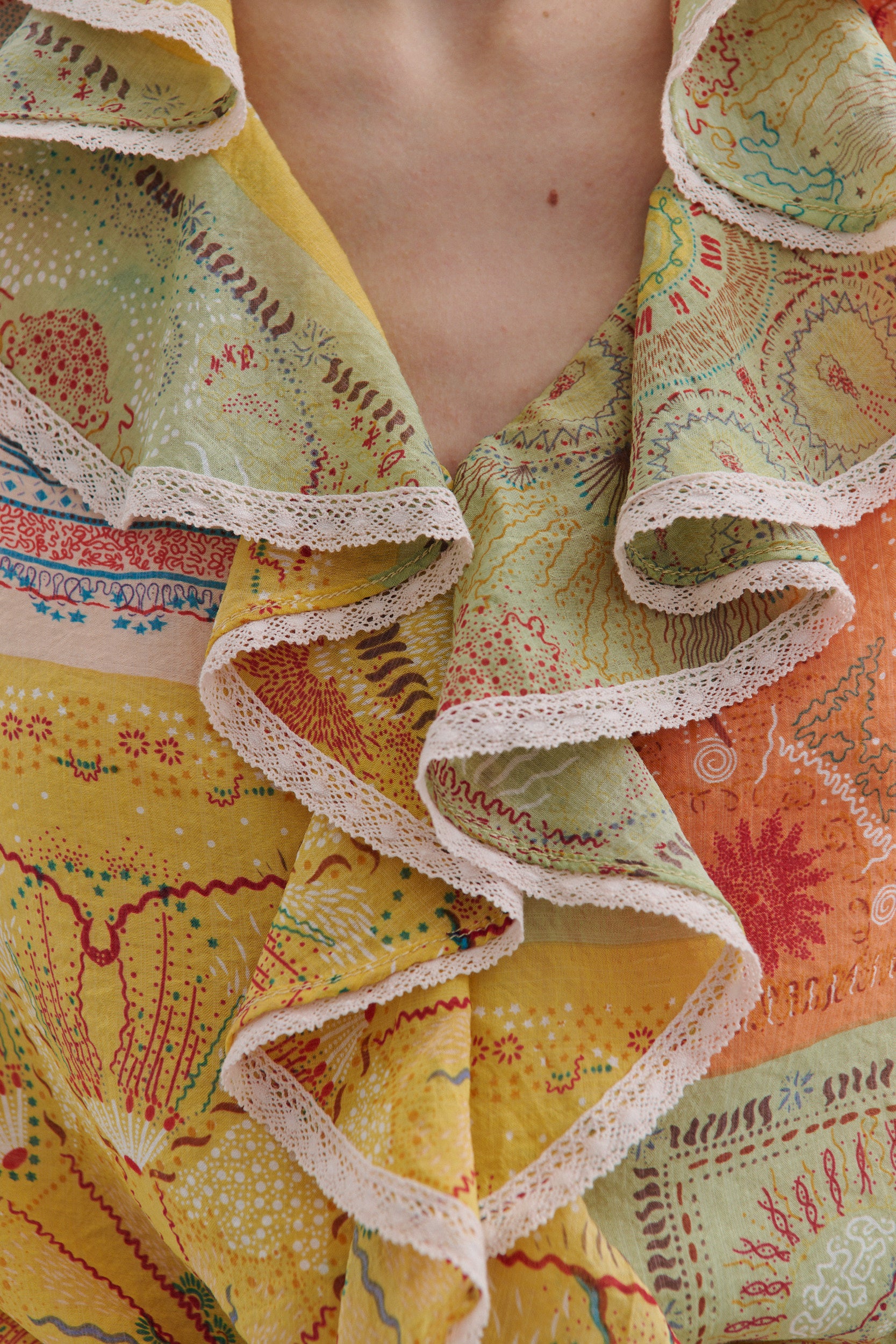 Close-up of a colorful fabric with ruffled edges and intricate patterns.