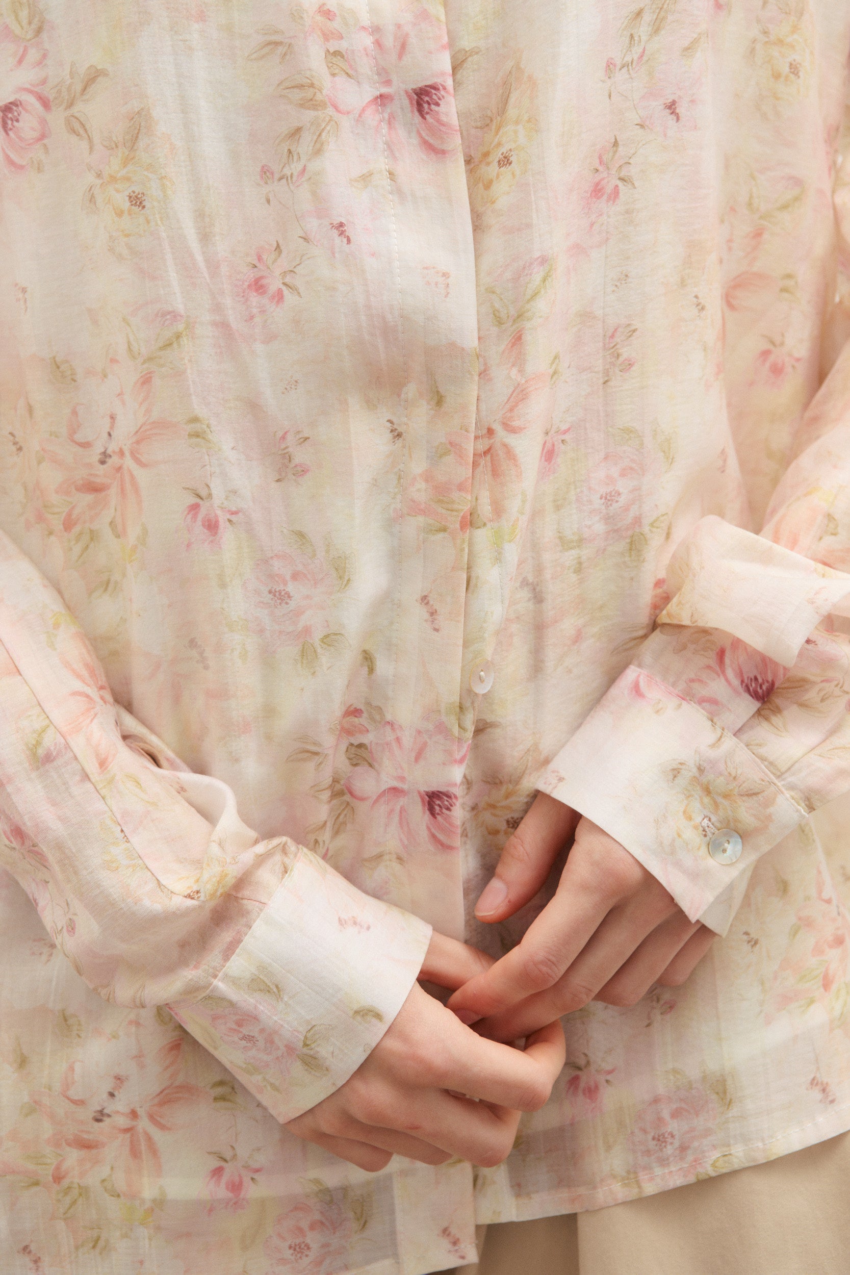 Floral patterned fabric with a close-up of hands wearing it